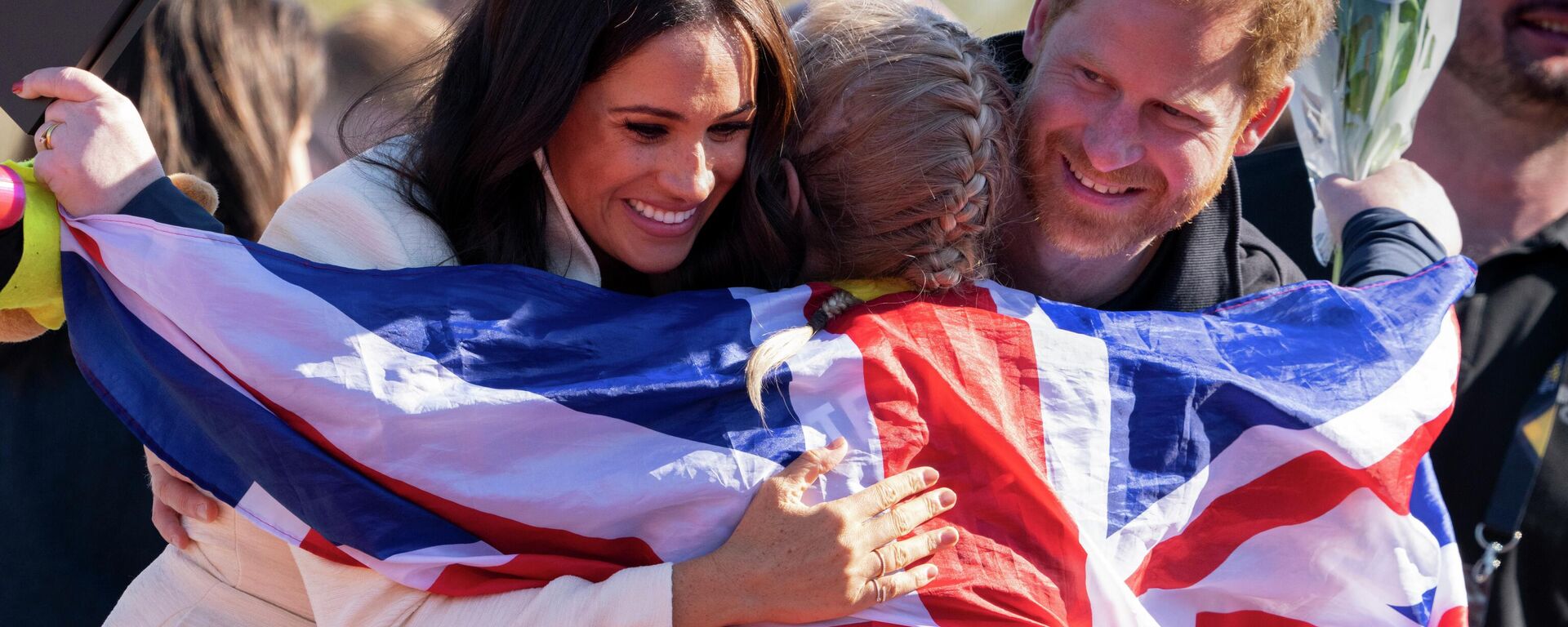 Prince Harry and Meghan Markle, Duke and Duchess of Sussex, hug Lisa Johnston, a former army medic and amputee, who celebrates with her medal at the Invictus Games venue in The Hague, Netherlands, Sunday, April 17, 2022 - Sputnik International, 1920, 22.04.2022