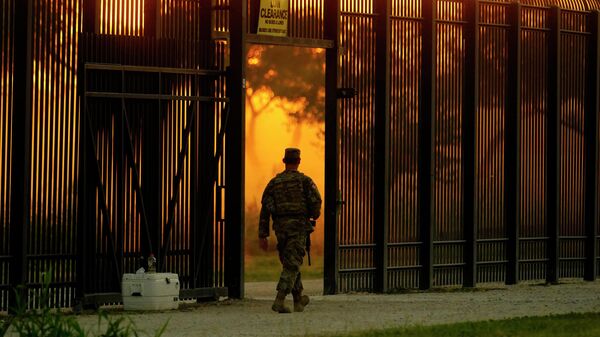 A National Guardsman stands guard at a fence that runs along the Rio Grande near the International bridge, Friday, Sept. 17, 2021, in Del Rio, Texas - Sputnik International