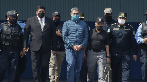 Former Honduran President Juan Orlando Hernandez, center, is taken in handcuffs to a waiting aircraft as he is extradited to the United States, at an Air Force base in Tegucigalpa, Honduras, Thursday, April 21, 2022.  - Sputnik International