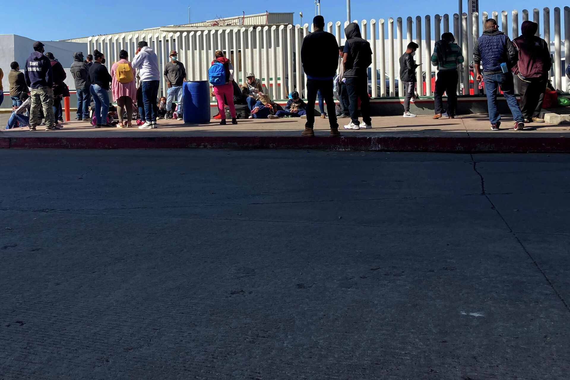 Migrants waiting to cross into the United States wait for news at the border crossing Wednesday, Feb. 17, 2021, in Tijuana, Mexico.   - Sputnik International, 1920, 15.12.2022