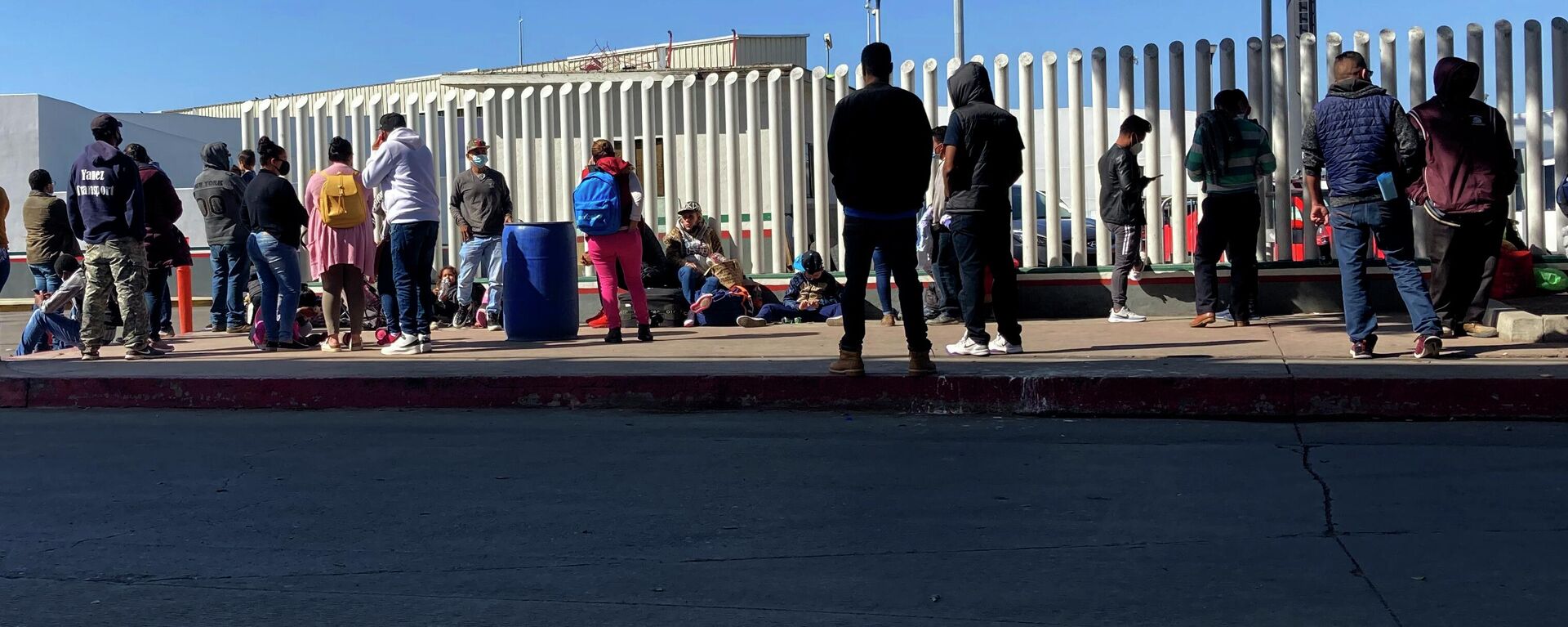 Migrants waiting to cross into the United States wait for news at the border crossing Wednesday, Feb. 17, 2021, in Tijuana, Mexico.   - Sputnik International, 1920, 24.04.2022
