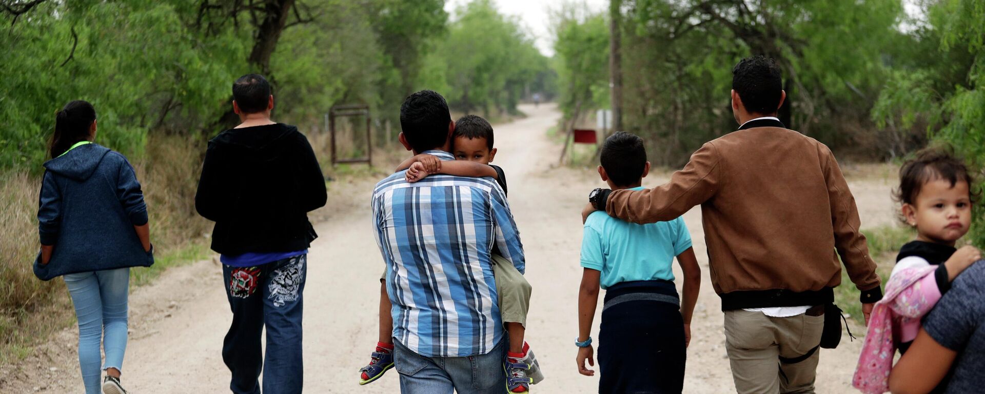 A group of migrant families walk from the Rio Grande, the river separating the U.S. and Mexico in Texas, near McAllen, Texas, March 14, 2019.  - Sputnik International, 1920, 28.04.2022