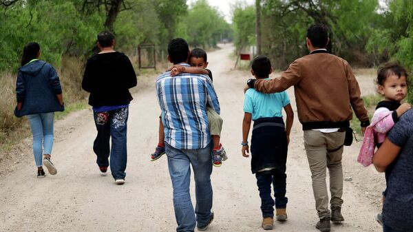 A group of migrant families walk from the Rio Grande, the river separating the US and Mexico in Texas, near McAllen, Texas, March 14, 2019.  - Sputnik International