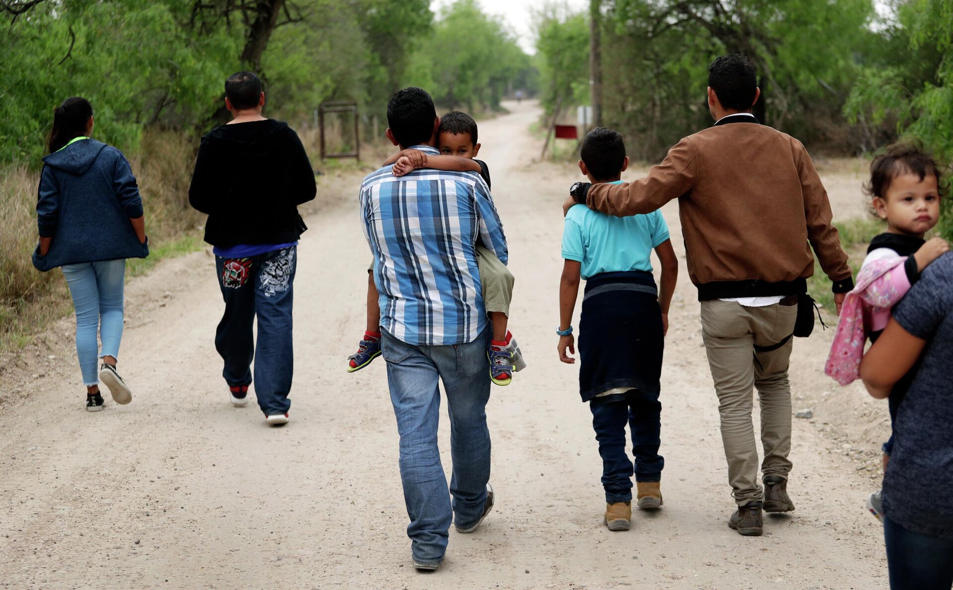 A group of migrant families walk from the Rio Grande, the river separating the U.S. and Mexico in Texas, near McAllen, Texas, March 14, 2019.  - Sputnik International, 1920, 24.04.2022