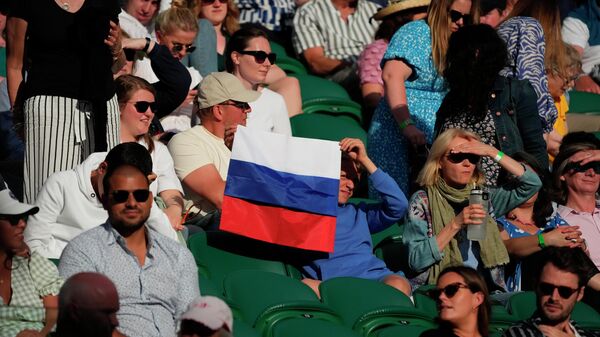 A spectator holding a Russian flag watches during the men's singles third round match between Russia's Daniil Medvedev and Croatia's Marin Cilic on day six of the Wimbledon Tennis Championships in London, Saturday July 3, 2021.  - Sputnik International