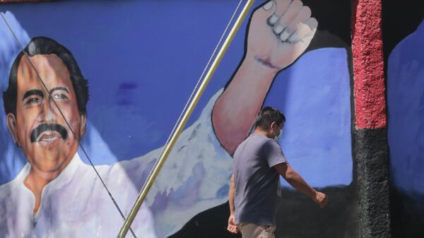 A man walks past a mural of Nicaraguan President Daniel Ortega during general elections in Managua, Nicaragua, Sunday, Nov. 7, 2021. - Sputnik International