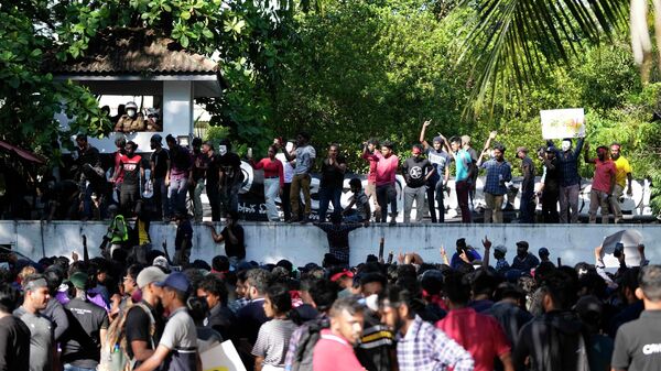 Sri Lankan university students shouts slogans against government during a protest over the country’s worst economic crisis in decades as they climb the wall of the residence of prime minister Mahinda Rajapaksa in Colombo, Sri Lanka - Sputnik International