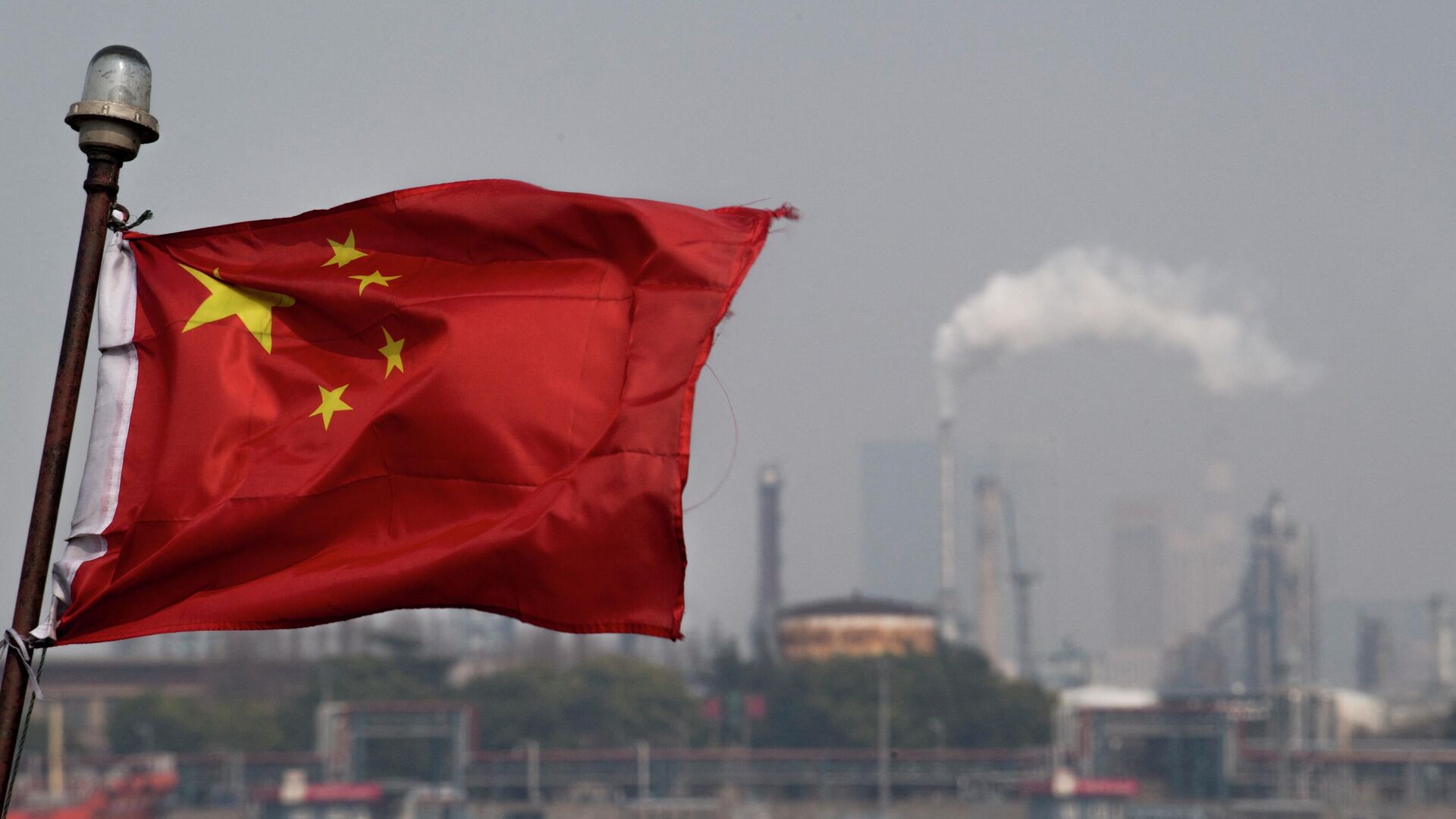 This picture taken on March 22, 2018 shows a Chinese flag fluttering in front of the Shanghai Gaoqiao Company Refinery in Shanghai. - Sputnik International, 1920, 04.05.2022