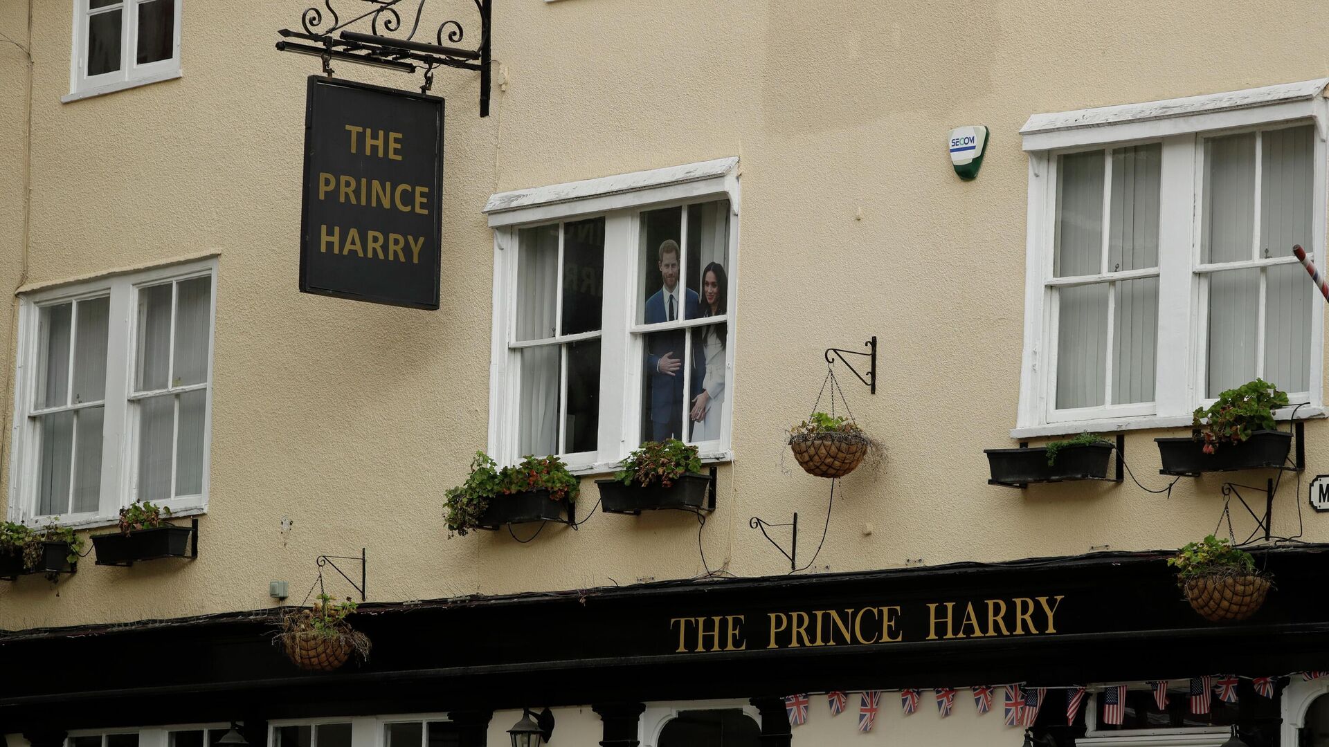 A large photograph of Prince Harry and his wife Meghan is displayed in an upstairs window of the Prince Harry pub, which is temporarily closed due to coronavirus restrictions, in Windsor, England, Tuesday, March 16, 2021 - Sputnik International, 1920, 04.05.2022
