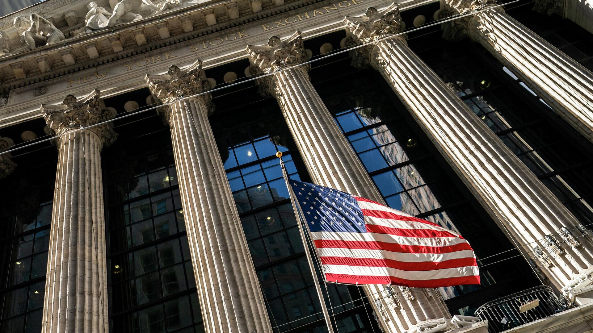 A U.S. flag waves outside the New York Stock Exchange, Monday, Jan. 24, 2022, in New York. Stocks are drifting between small gains and losses in the early going on Wall Street Tuesday, May 3, 2022 as investors await Wednesday's decision by the Federal Reserve on interest rates. The Fed is expected to raise its benchmark rate by twice the usual amount this week as it steps up its fight against inflation, which is at a four-decade high. - Sputnik International, 1920, 22.06.2022