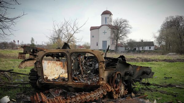 Fragments of a destroyed Russian military vehicle lie against the background of an Orthodox church in the village of Lypivka close to Kiev, Ukraine, on April 11, 2022.  - Sputnik International