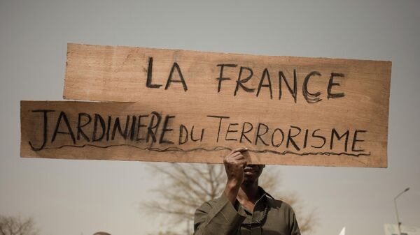 A protester holds a placard reading France, gardener of terrorism  during a demonstration organised by the pan-Africanst platform Yerewolo to celebrate France's announcement to withdraw French troops from Mali, in Bamako, on February 19, 2022 - Sputnik International
