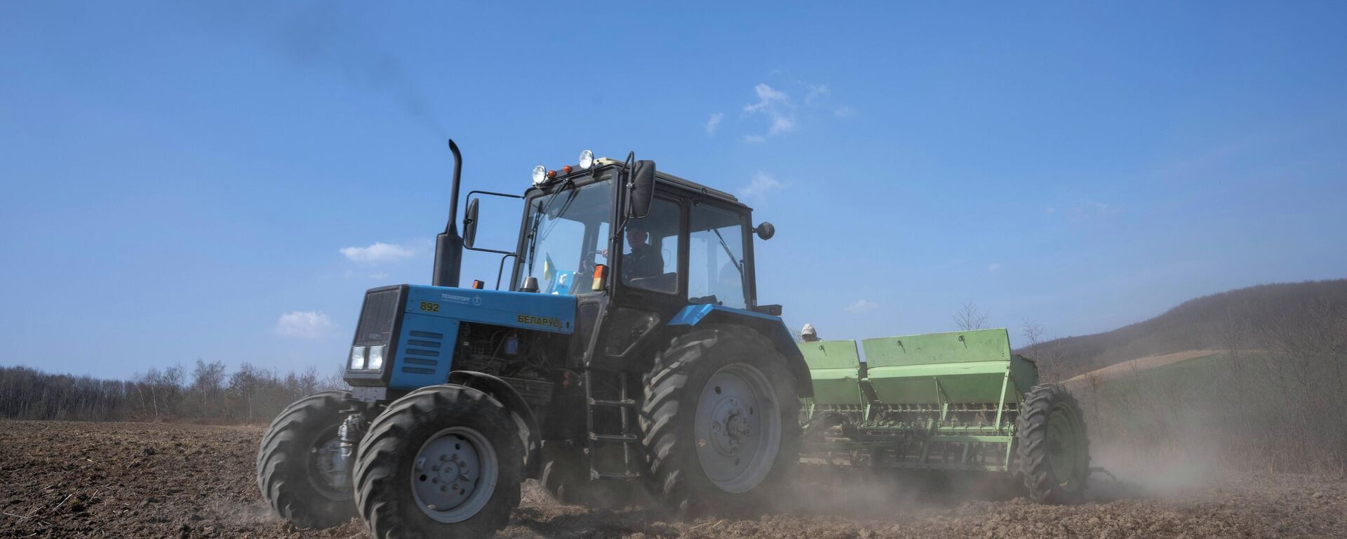 Workers plow wheat on the land belonging to Vasyl Pidhaniak, in Husakiv village, western Ukraine, Saturday, March 26, 2022 - Sputnik International, 1920, 06.05.2022