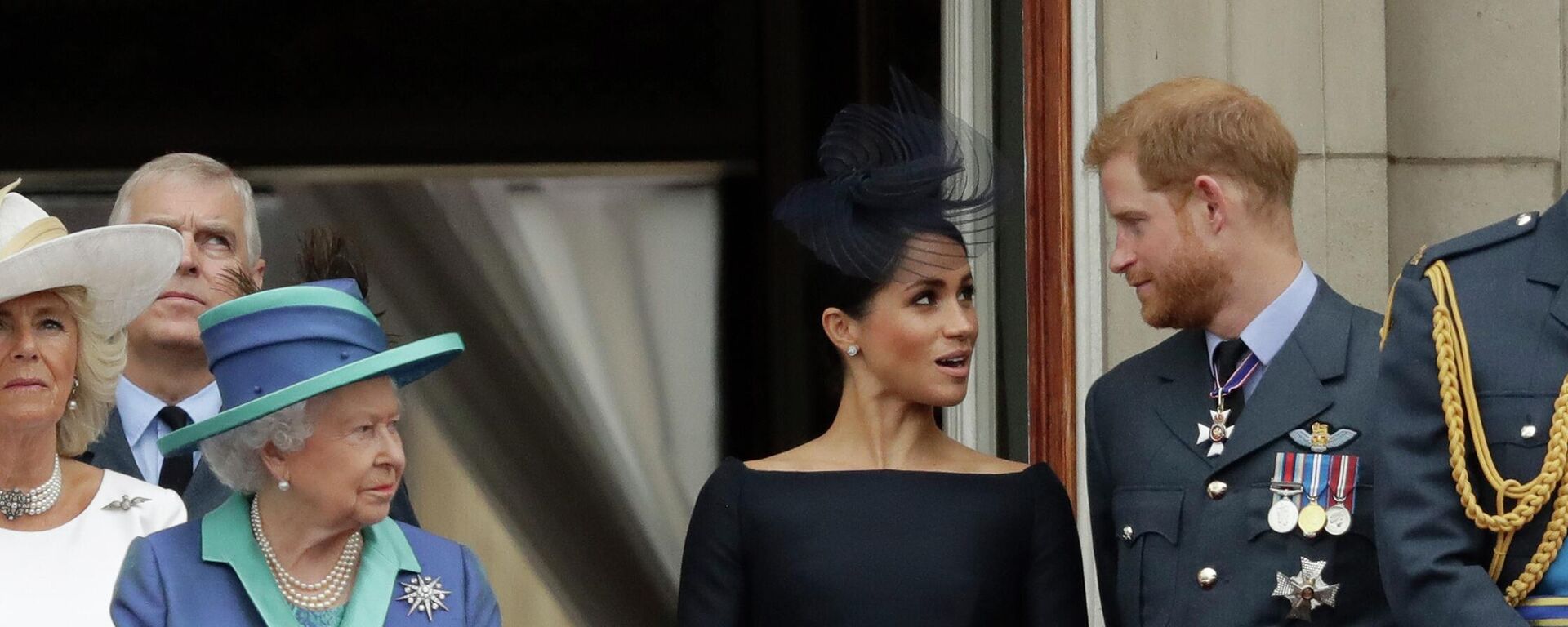In this Tuesday, July 10, 2018 file photo Britain's Queen Elizabeth II, Meghan the Duchess of Sussex and Prince Harry stand on a balcony to watch a flypast of Royal Air Force aircraft pass over Buckingham Palace in London. - Sputnik International, 1920, 07.05.2022
