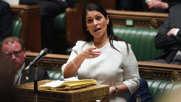 A handout photograph released by the UK Parliament shows Britain's Home Secretary Priti Patel gesturing as she gives a statement concerning the deal plan to send migrants and asylum seekers who cross the Channel to Rwanda, at the House of Commons, in London, on April 19, 2022 - Sputnik International