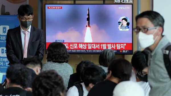 People watch a TV showing a file image of North Korea's missile launch during a news program at the Seoul Railway Station in Seoul, South Korea, Saturday, May 7, 2022. - Sputnik International