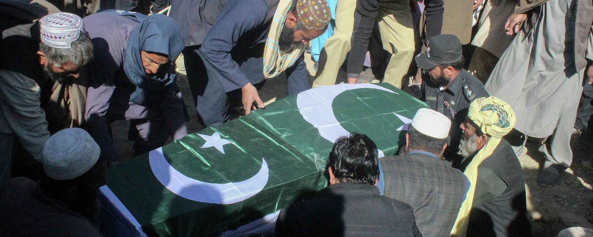 Security officials along with relatives bury the coffin of a slain policeman, killed in an attack claimed by the Tehreek-e-Taliban Pakistan (TTP), during his funeral in the border town of Chaman on January 28, 2022.  - Sputnik International, 1920, 09.05.2022
