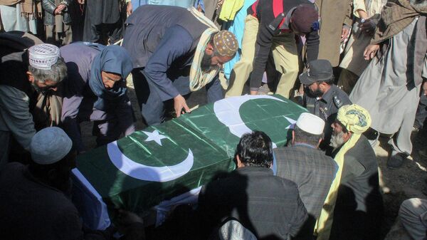 Security officials along with relatives bury the coffin of a slain policeman, killed in an attack claimed by the Tehreek-e-Taliban Pakistan (TTP), during his funeral in the border town of Chaman on January 28, 2022.  - Sputnik International
