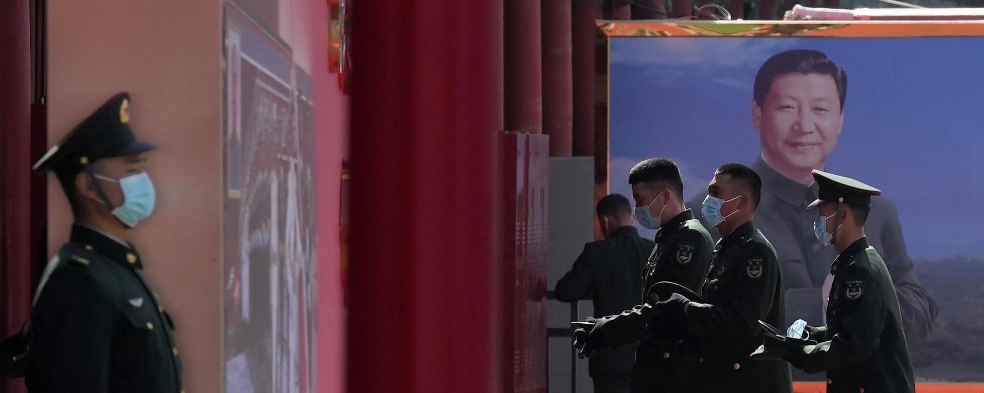 Chinese military personnel pass by a board displaying a photo of Chinese President Xi Jinping on March 4, 2022, in Beijing.  - Sputnik International, 1920, 10.05.2022