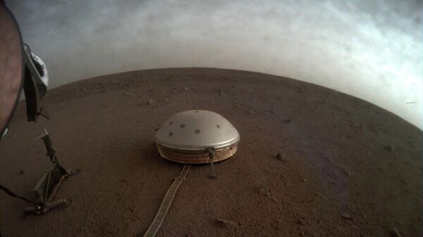In this undated photo made available by NASA on Thursday,  July 22, 2021, clouds drift over the dome-covered SEIS seismometer of the InSight lander on the surface of Mars. - Sputnik International