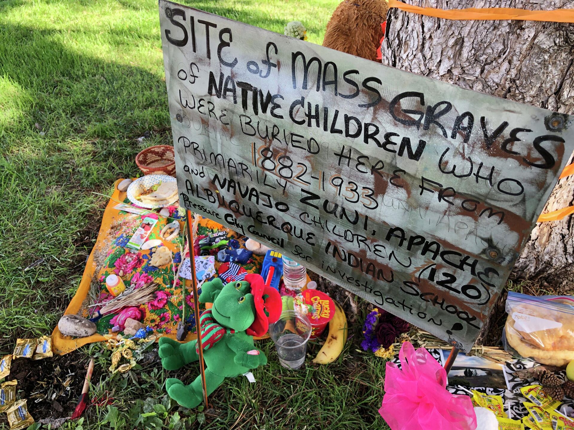 A makeshift memorial for the dozens of Indigenous children who died more than a century ago while attending a boarding school that was once located nearby is displayed under a tree at a public park in Albuquerque, N.M., on  July 1, 2021.  - Sputnik International, 1920, 08.08.2022