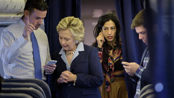 Democratic presidential nominee Hillary Clinton (2L) looks at national press secretary Brian Fallon's (L) smart phone while on her plane with aid Huma Abedin (2R) and traveling press secretary Nick Merrill (R) at Westchester County Airport October 3, 2016 in White Plains, New York - Sputnik International