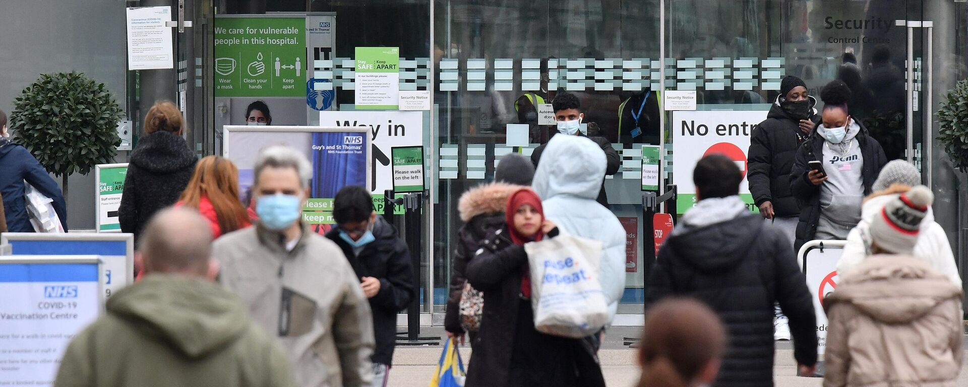 People, some wearing face coverings to combat the spread of Covid-19, arrive at, and depart from, St Thomas' hospital in central London on December 23, 2021 - Sputnik International, 1920, 22.05.2022