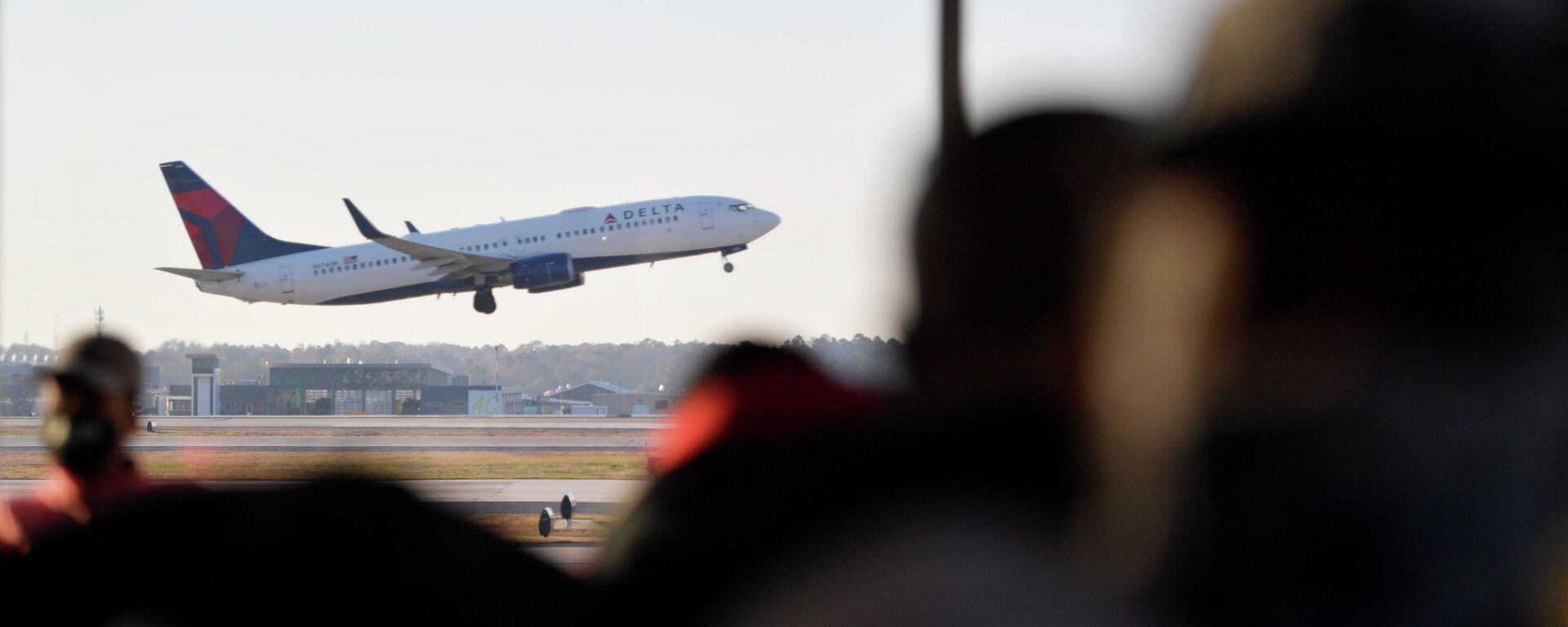 A Delta Airlines aircraft takes off as passengers await the boarding process, Thursday, Dec. 2, 2021, at Hartsfield-Jackson Atlanta International Airport, in Atlanta. - Sputnik International, 1920, 25.07.2022