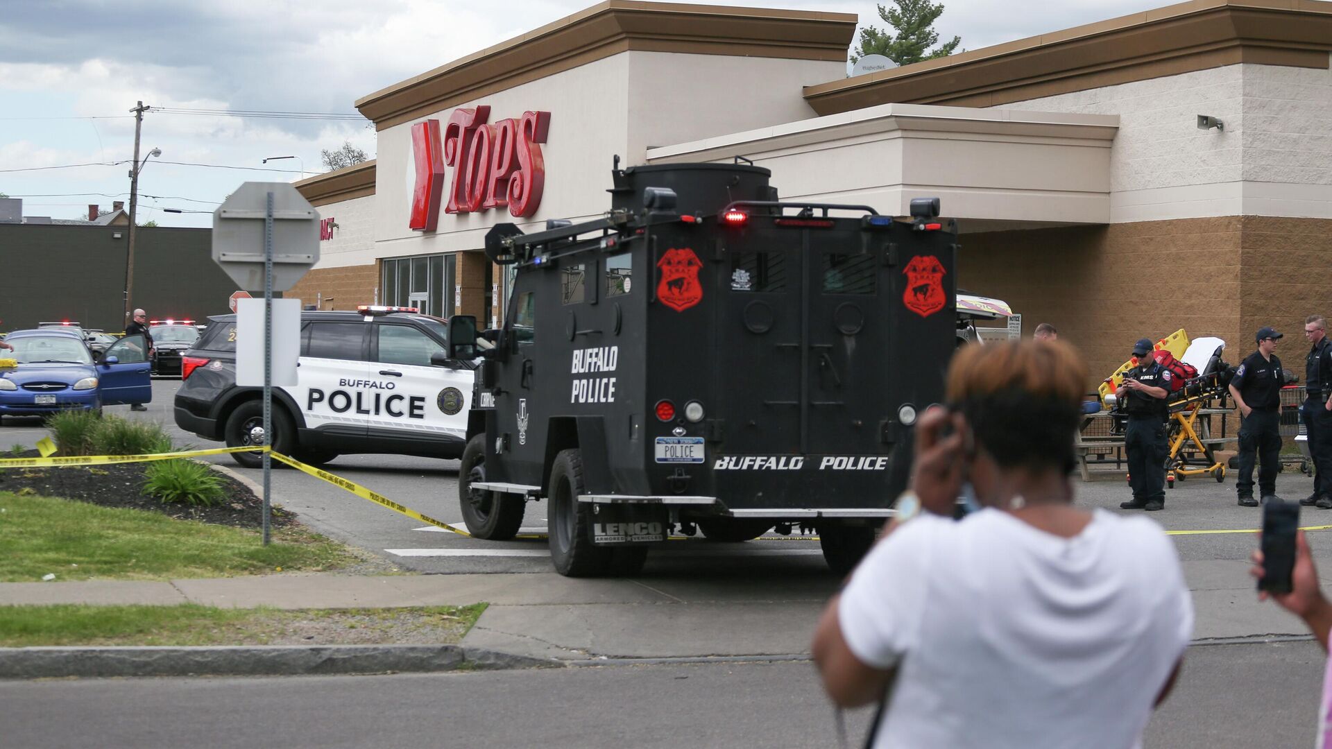A crowd gathers as police investigate after a shooting at a supermarket on Saturday, May 14, 2022, in Buffalo, N.Y. Multiple people were shot  at the Tops Friendly Market.  Police have notified the public that the alleged shooter was in custody.  - Sputnik International, 1920, 14.05.2022