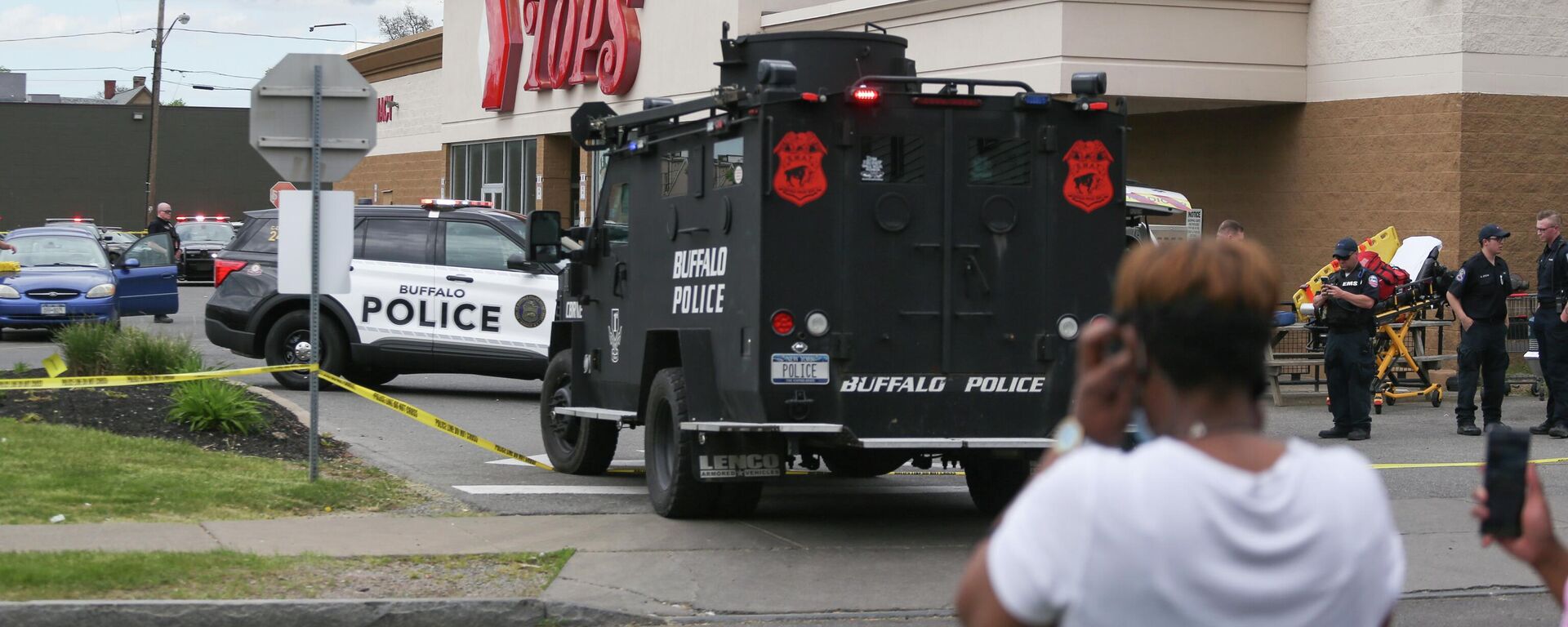 A crowd gathers as police investigate after a shooting at a supermarket on Saturday, May 14, 2022, in Buffalo, N.Y. Multiple people were shot  at the Tops Friendly Market.  Police have notified the public that the alleged shooter was in custody.  - Sputnik International, 1920, 16.05.2022