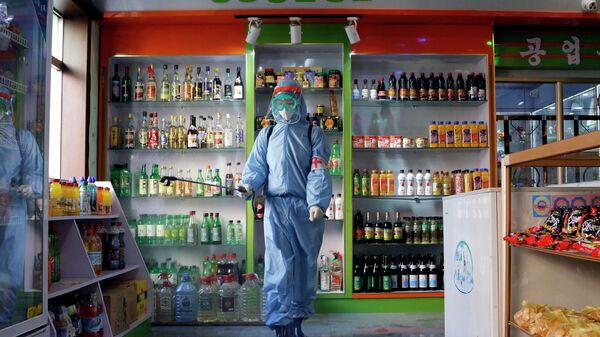 FILE - An employee of the Kyonghung Foodstuff General Store disinfects the showroom in Pyongyang, North Korea, Wednesday, Nov. 10, 2021. Before acknowledging domestic COVID-19 cases, Thursday, May 12, 2022, North Korea spent 2 1/2 years rejecting outside offers of vaccines and steadfastly claiming that its superior socialist system was protecting its 26 million people from “a malicious virus” that had killed millions around the world. - Sputnik International