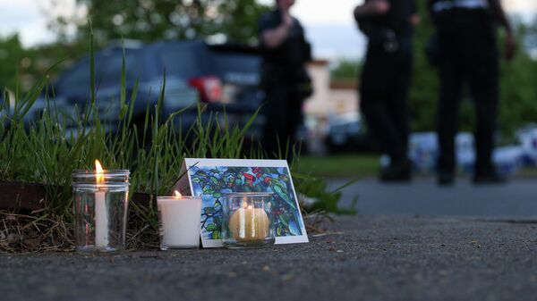 Police walk by a small memorial as they investigate after a shooting at a supermarket on Saturday, May 14, 2022, in Buffalo, N.Y. - Sputnik International