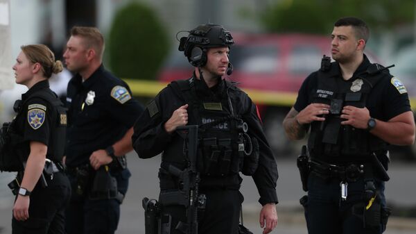 Police walk along the perimeter of the scene after a shooting at a supermarket on Saturday, May 14, 2022, in Buffalo, N.Y.  Officials said the gunman entered the supermarket with a rifle and opened fire. Investigators believe the man may have been livestreaming the shooting and were looking into whether he had posted a manifesto online.  - Sputnik International