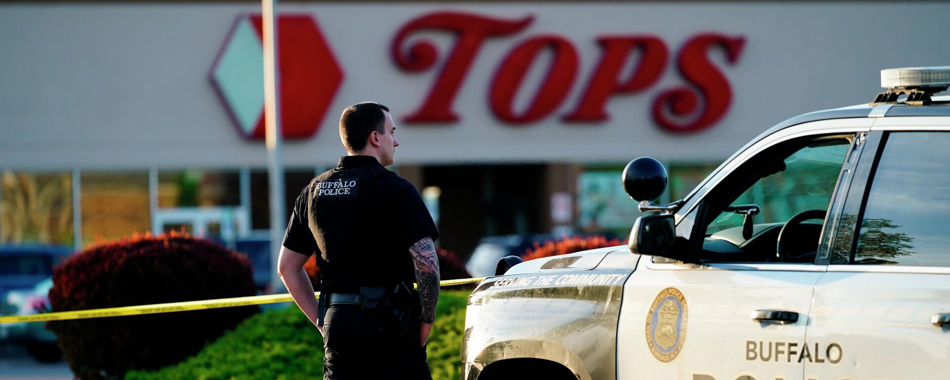 A police officer stands guard outside the scene of a shooting at a supermarket, in Buffalo, N.Y., Sunday, May 15, 2022. - Sputnik International, 1920, 03.06.2022