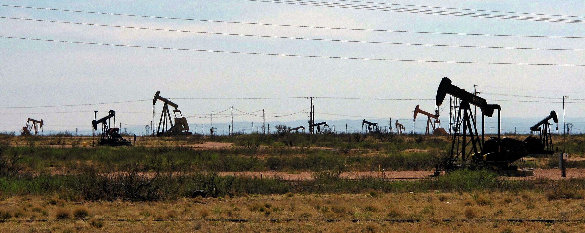 Oil rigs stand in the Loco Hills field along U.S. Highway 82 in Eddy County, near Artesia, N.M., one of the most active regions of the Permian Basin. - Sputnik International, 1920, 12.09.2022