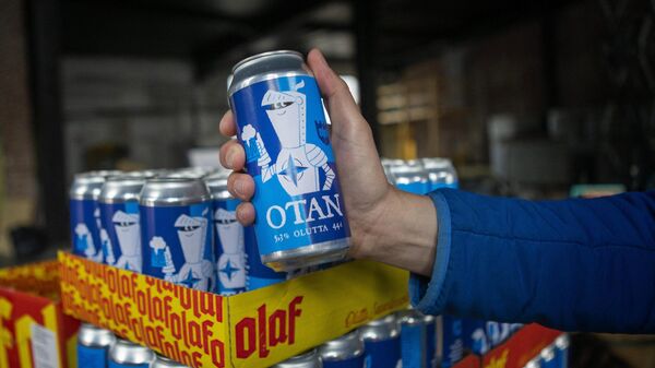 A hand holds a Nato-branded OTAN beer can produced by the Olaf Brewing Company in Savonlinna, eastern Finland, on May 17, 2022 - Sputnik International