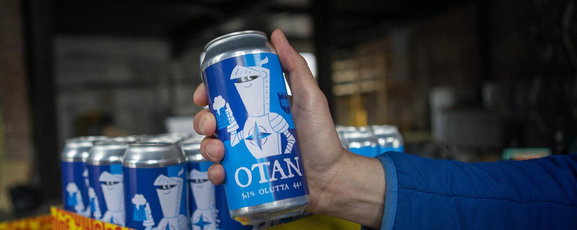 A hand holds a Nato-branded OTAN beer can produced by the Olaf Brewing Company in Savonlinna, eastern Finland, on May 17, 2022 - Sputnik International, 1920, 17.05.2022