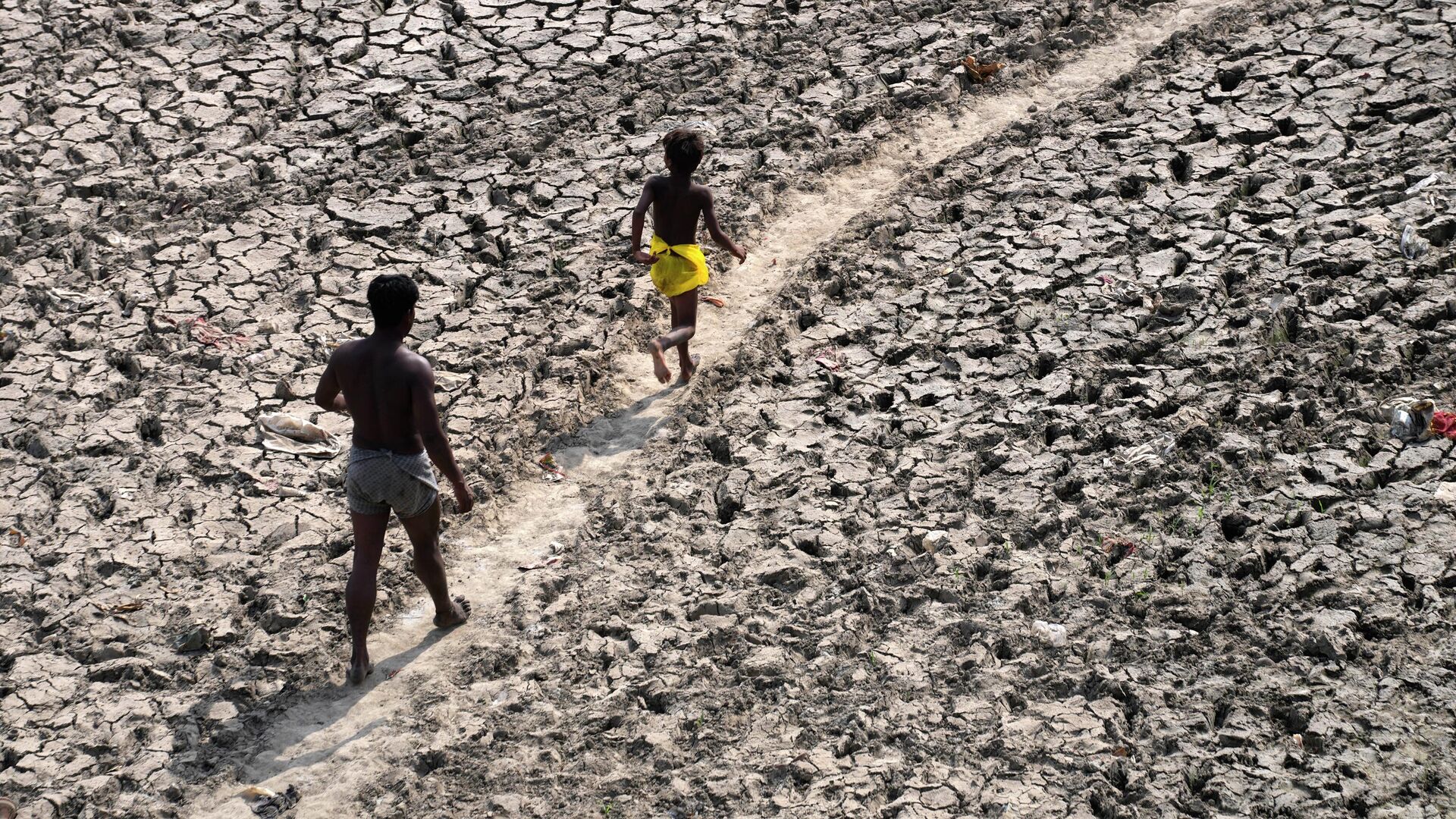 A man and a boy walk across an almost dried up bed of river Yamuna following hot weather in New Delhi, India, Monday, May 2, 2022 - Sputnik International, 1920, 17.05.2022