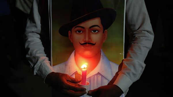A member of a left wing party holds a portrait of Bhagat Singh as they participate in a candle light rally to pay tribute to freedom fighters Bhagat Singh, Sukhdev and Rajguru who were executed by the British on March 23, 1931, in Hyderabad, India, Tuesday, March 23, 2021 - Sputnik International