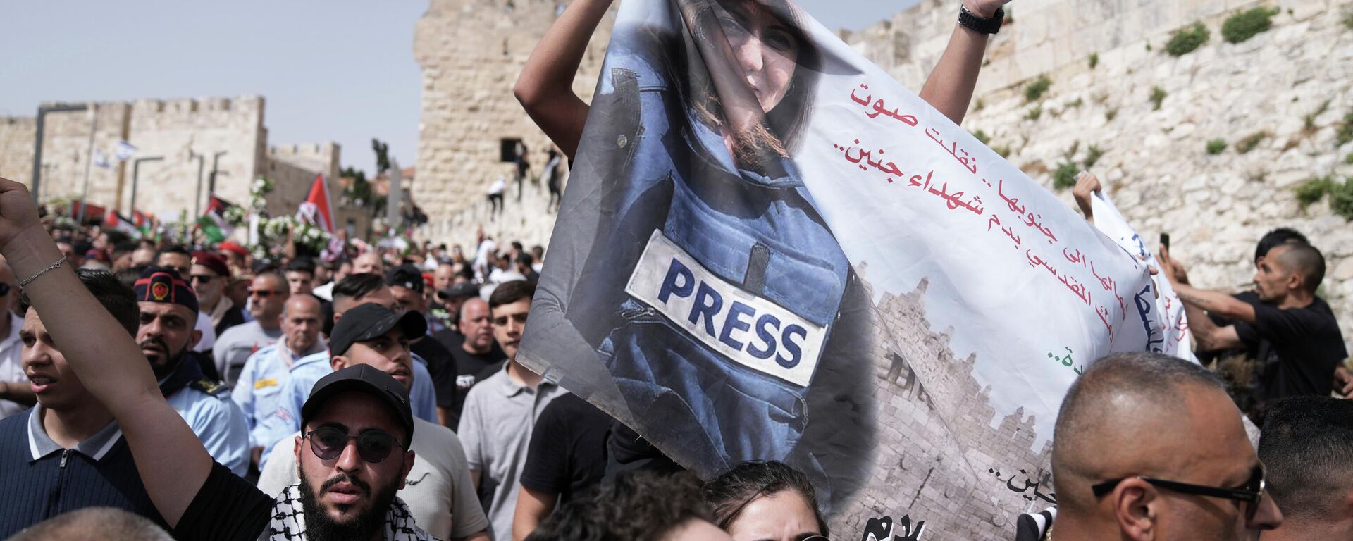 Mourners hold a banner depicting slain Al Jazeera veteran journalist Shireen Abu Akleh as they walk from the Old City of Jerusalem to her burial site, Friday, May 13, 2022. - Sputnik International, 1920, 13.07.2022