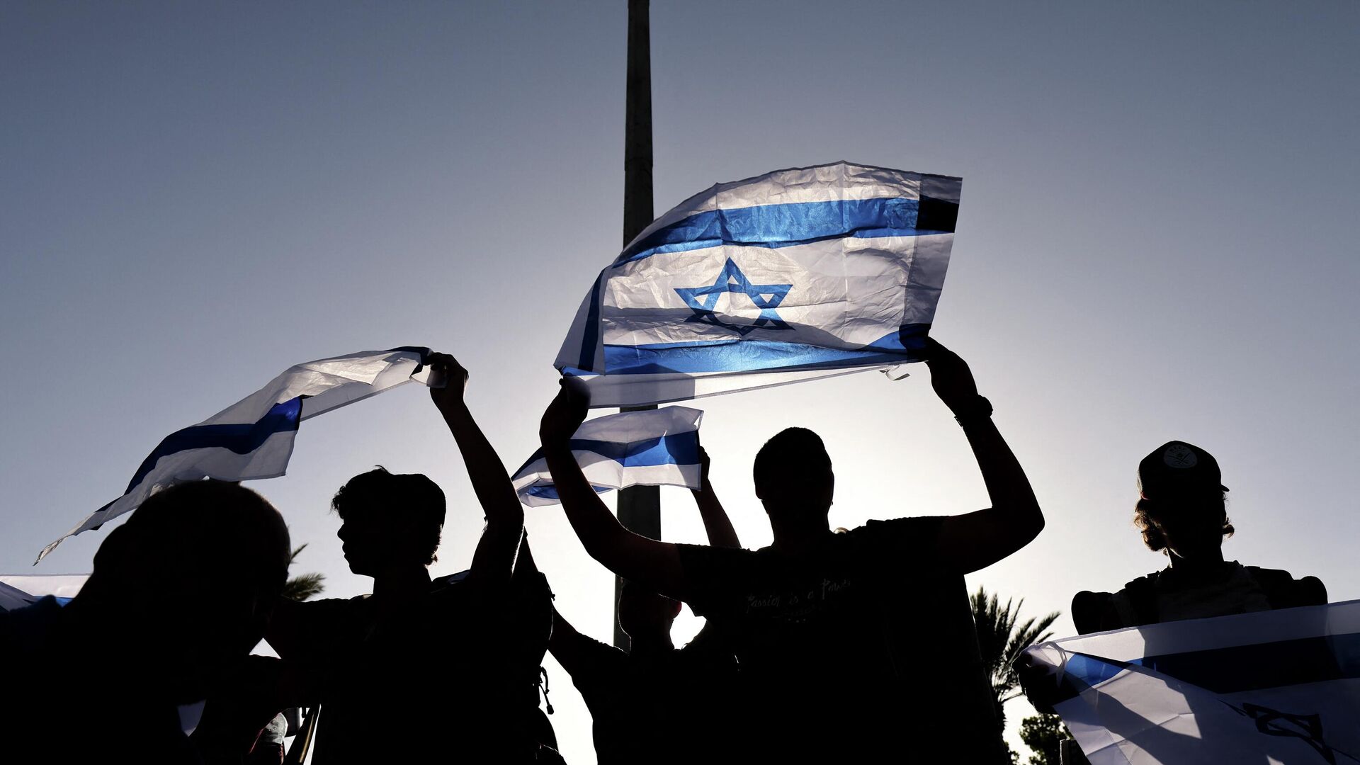Supporters of Itamar Ben-Gvir, member of Israel's Knesset (parliament) and head of the one-man far right Jewish Power (Otzma Yehudit) party, wave their country's national flag as he attempts to march to Damascus Gate in east Jerusalem, on June 10, 2021. - Sputnik International, 1920, 18.10.2022