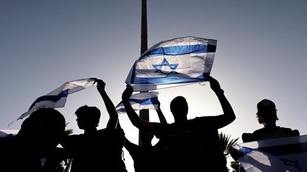 Supporters of Itamar Ben-Gvir, member of Israel's Knesset (parliament) and head of the one-man far right Jewish Power (Otzma Yehudit) party, wave their country's national flag as he attempts to march to Damascus Gate in east Jerusalem, on June 10, 2021. - Sputnik International