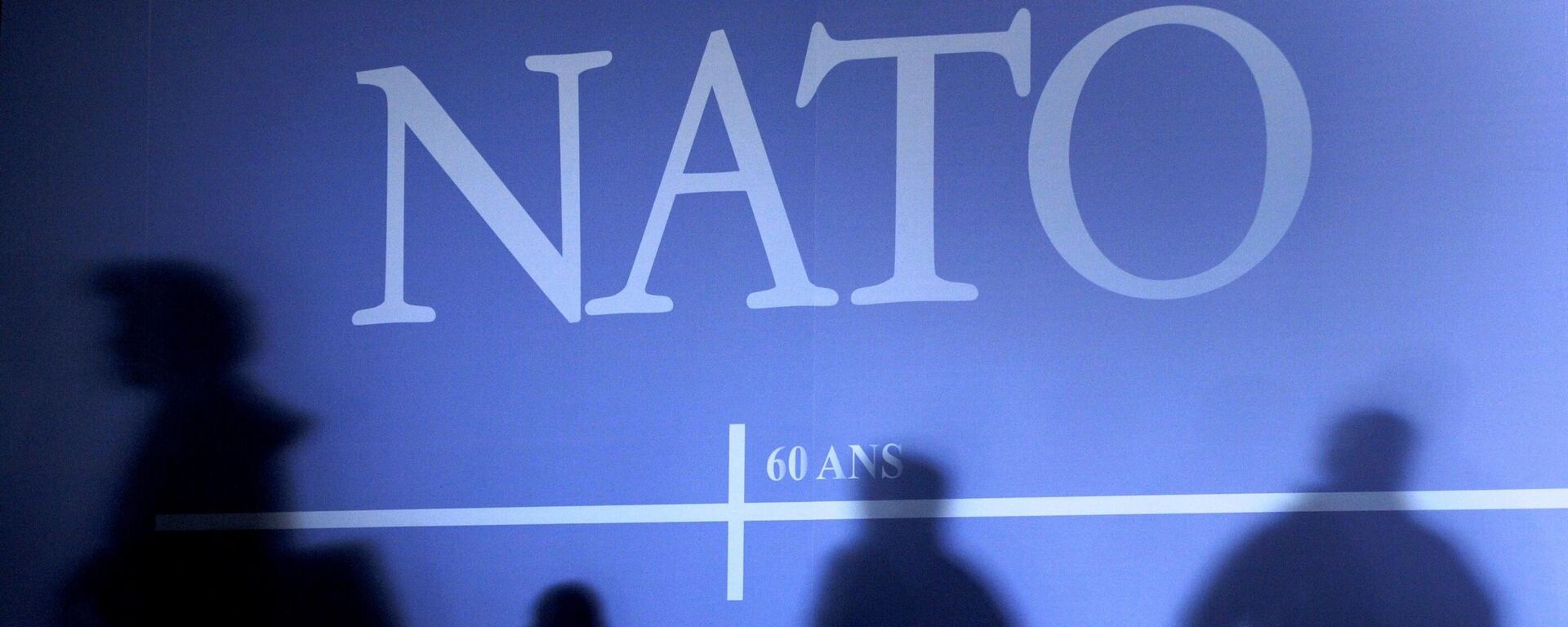 This April 2, 2009 file photo shows shadows cast on a wall decorated with the NATO logo and flags of NATO countries in Strasbourg, eastern France, before the start of the NATO summit which marked the organisation's 60th anniversary.  - Sputnik International, 1920, 27.03.2023