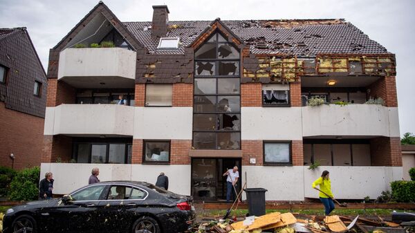Residents clear the debris in front of an appartment building in Paderborn, western Germany on May 20, 2022, after a storm caused major damage. - Sputnik International