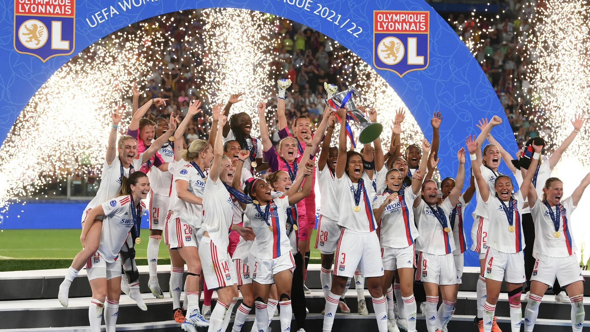 Lyon's French defender Wendie Renard (C) lifts the trophy as she celebrates with teammates on the podium after winning the UEFA Women’s Champions League Final football match between Spain's Barcelona and France's Lyon at the Allianz Stadium in the Italian city of Turin on May 21, 2022.  - Sputnik International, 1920, 21.05.2022
