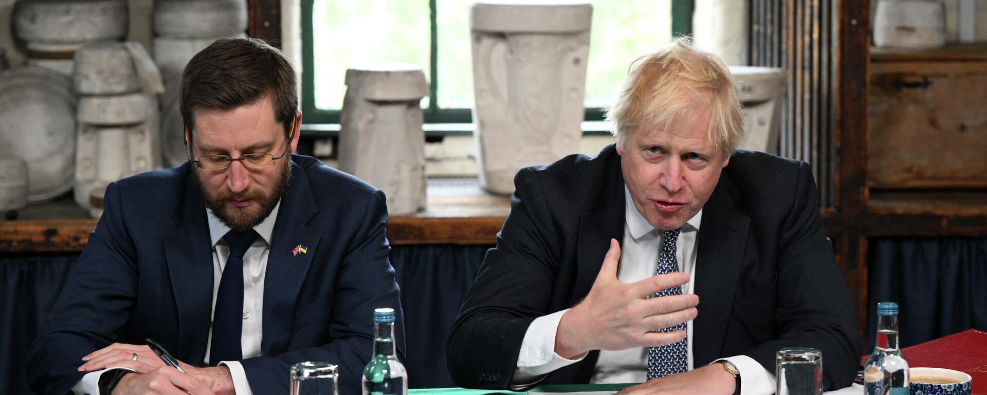 Britain's Prime Minister Boris Johnson (R), flanked by Britain's Cabinet Secretary and Head of the Civil Service Simon Case, chairs a Cabinet meeting at a pottery in Stoke-on-Trent, central England, on May 12, 2022 - Sputnik International, 1920, 22.05.2022