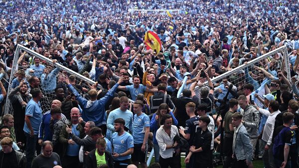 Manchester City's fans celebrate as they invade the pitch at the end of the English Premier League football match between Manchester City and Aston Villa at the Etihad Stadium in Manchester, north west England, on May 22, 2022. - Sputnik International