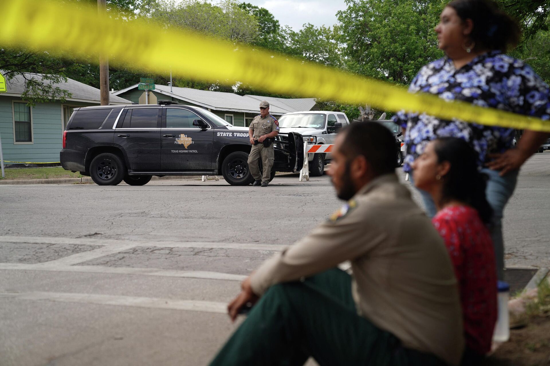 People sit on the curb outside of Robb Elementary School as State troopers guard the area in Uvalde, Texas, on May 24, 2022 - Sputnik International, 1920, 26.05.2022
