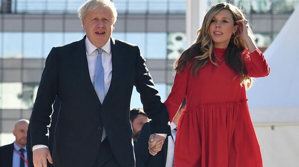 Britain's Prime Minister Boris Johnson (L) and his wife Carrie (R) arrive at the Manchester Central convention centre ahead of his keynote speech on the final day of the annual Conservative Party Conference in Manchester, northwest England, on October 6, 2021 - Sputnik International
