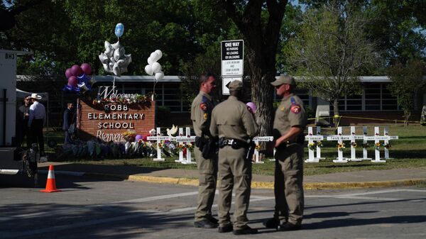 Police officers stand next to a makeshift memorial outside the Robb Elementary School on May 26, 2022 in Uvalde, Texas - Sputnik International